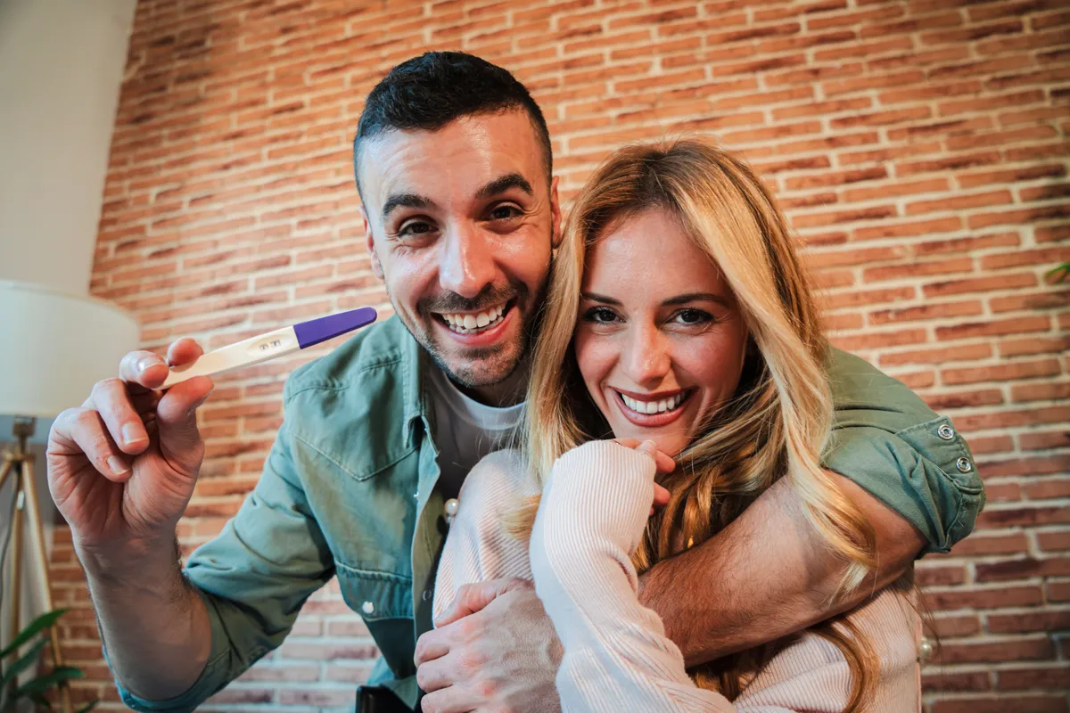 Pareja feliz con prueba de embarazo